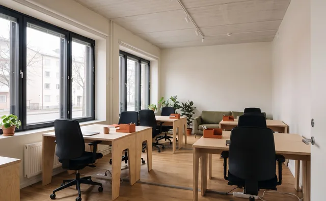 Desks by the large windows in the M8S private office